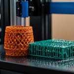 Advanced 3D printing facility with multiple additive manufacturing systems producing complex parts, material research displays, and innovative printed objects